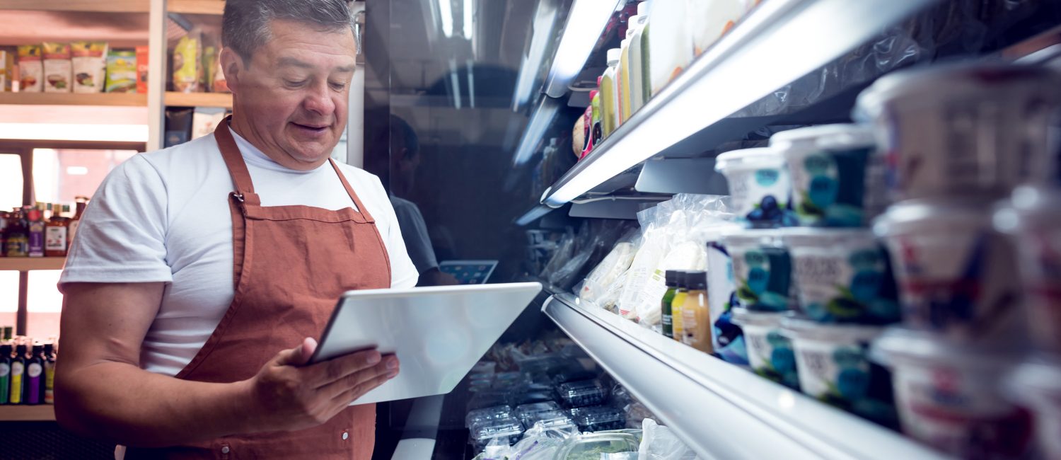 Man working at a grocery store Happy man working at a grocery store doing the inventory - small business concepts